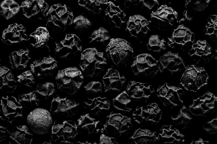 A close-up view of black peppercorns.